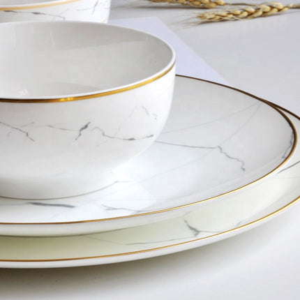 White ceramic plates with gold rims on a light background